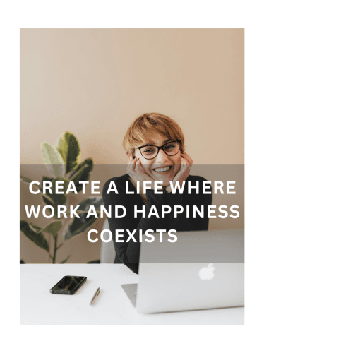 Smiling woman with short hair and glasses sitting at a desk with a laptop, phone, and pen.