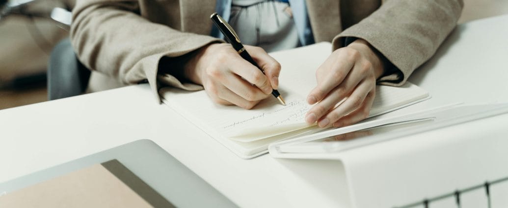 Woman writing in a notebook while setting clear career goals and planning her personal growth strategy.