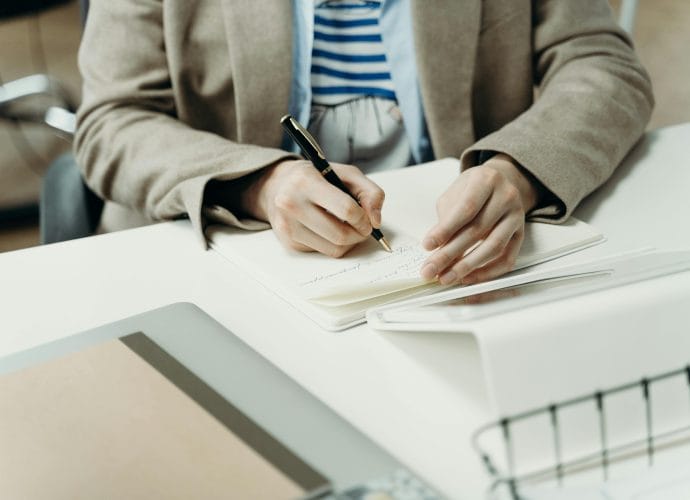 Woman writing in a notebook while setting clear career goals and planning her personal growth strategy.