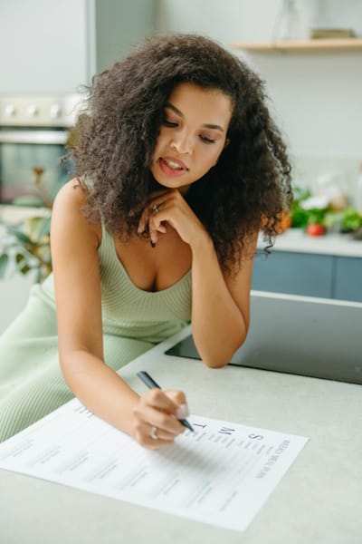 Woman planning weekly meals using a printable meal planner at home