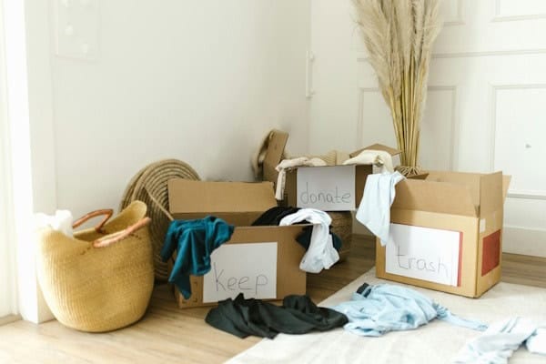 Four labeled boxes for decluttering clothes: Keep, Donate, Trash, and Relocate