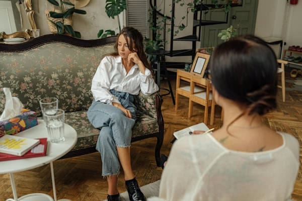 Woman in therapy session with a mental health professional, representing emotional support and guidance for PTSD and mental health recovery.