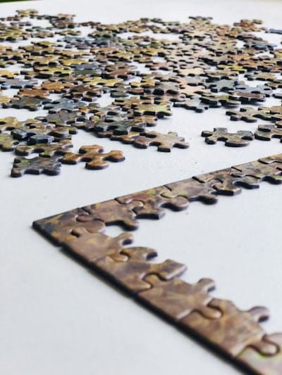 Close-up of jigsaw puzzle pieces gradually forming a picture, symbolizing how small consistent steps create lasting change