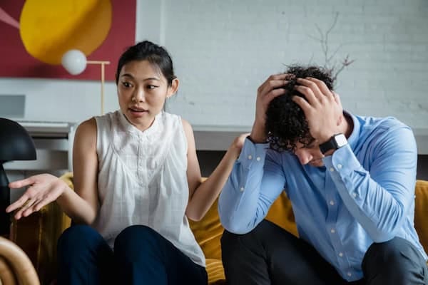 Frustrated couple having a tense conversation, symbolizing inner conflict and the limiting beliefs that hold people back from making life changes.
