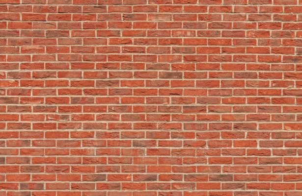 Red brick wall symbolizing how consistent small steps build a strong and lasting foundation for personal growth