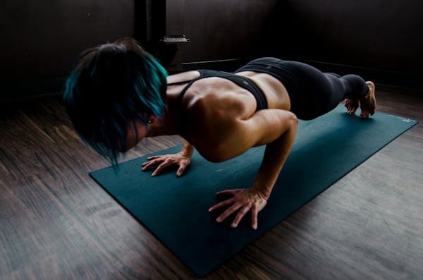 Woman practicing advanced yoga pose on a mat, symbolizing discipline, consistency, and commitment to personal growth