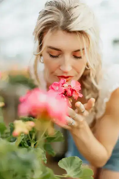 Woman gently smelling a flower, representing self-talk, mindfulness, and calming the inner critic