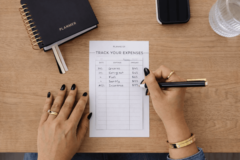 Woman tracking her spending habits and daily expenses in a notebook