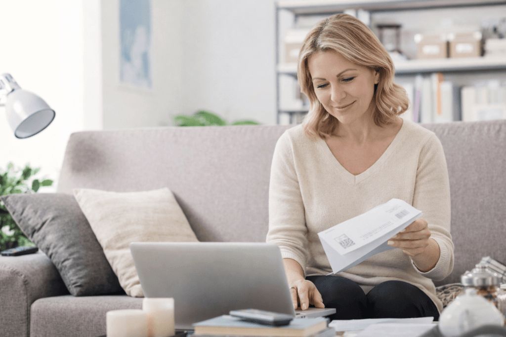 Woman in her 40s reviewing a utility bill and paying fixed costs online from home