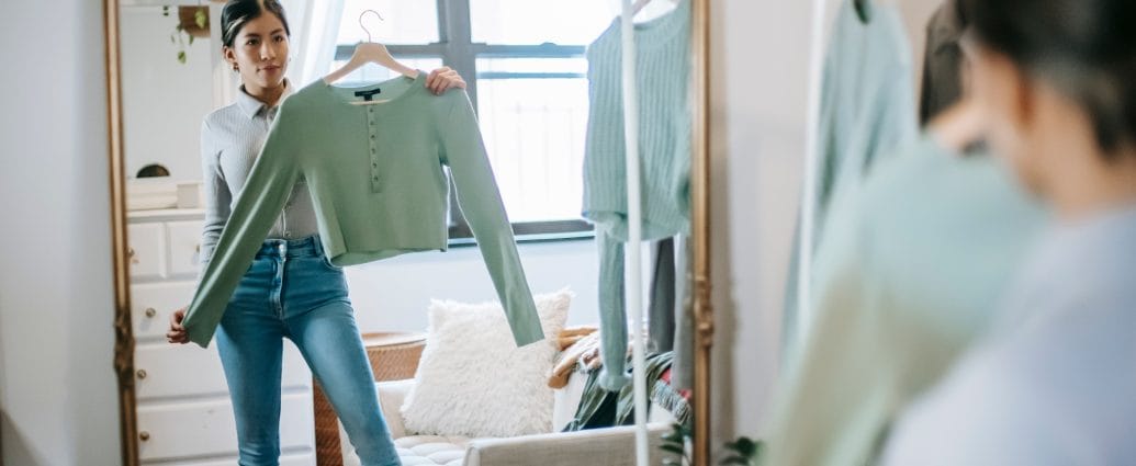 Woman over 40 choosing clothes at home as part of rebuilding personal style, confidence, and self-respect.