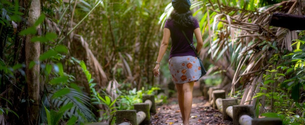 Woman making time for hobbies by walking on a forest trail
