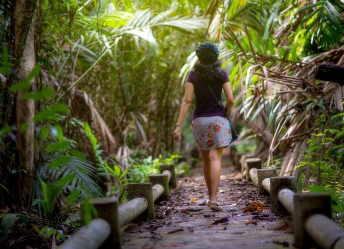 Woman making time for hobbies by walking on a forest trail