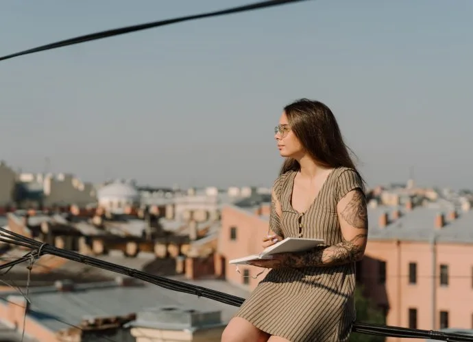 Woman writing in a journal while visualizing the healthy relationships she wants in her life.
