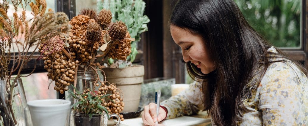 Woman analyzing her life by writing in a journal using the AVM Method