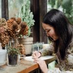 Woman analyzing her life by writing in a journal using the AVM Method