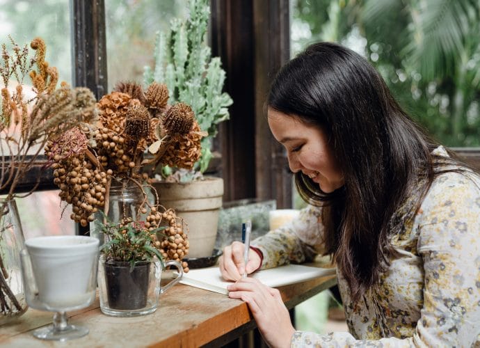 Woman analyzing her life by writing in a journal using the AVM Method